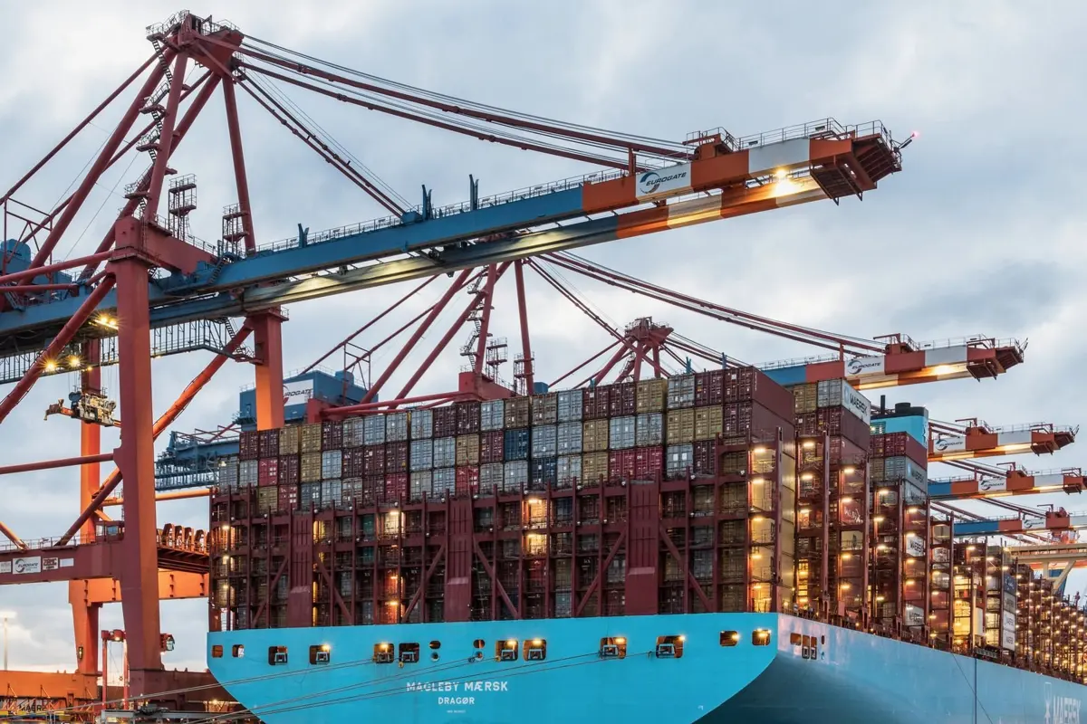 Guindastes e navio porta-contêineres em porto