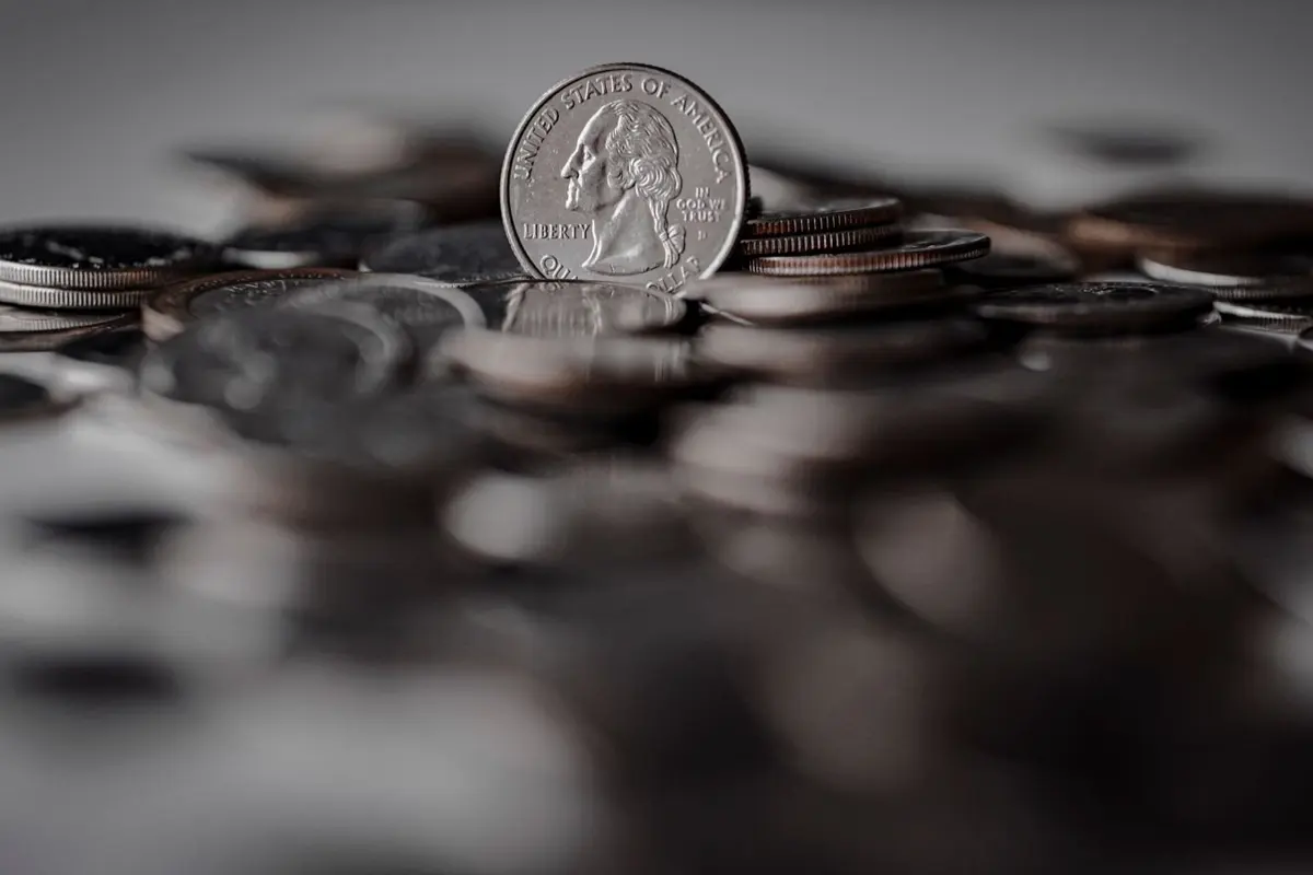 Moeda de prata em pé sobre pilha de moedas