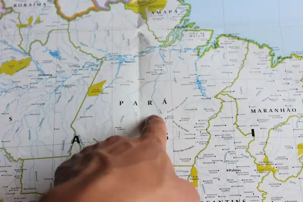 Mão apontando o estado do Pará em um mapa do Brasil