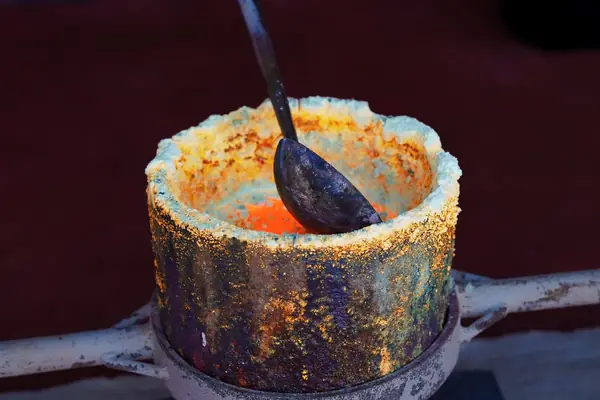 Cadinho com ouro fundido e uma concha