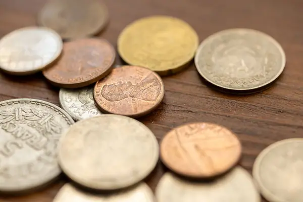 Moedas antigas sobre uma mesa de madeira