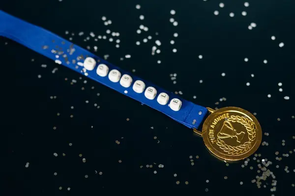 Medalha dourada em close sobre fundo escuro
