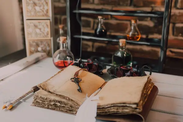 Livros antigos, frascos e uma chave sobre uma mesa